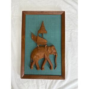 Hand carved wooden elephant plaque on wooden frame and teal fabric Thailand